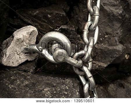 Steel Bolt Anchor Eye In Hard Basalt Rock. End Of Steel Chain