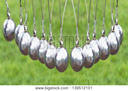 Newton's Cradle or pendulum ball Newton pendulum also called Newton's cradle. Physics is action reaction and concept or cause and effect.