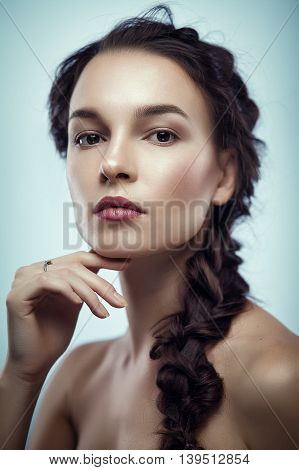 Fashion portrait of gorgeous young brunetee woman.Chaos hair style with braid. Shallow depth of field