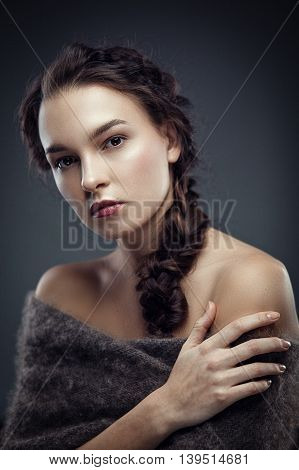 Fashion portrait of gorgeous young brunetee woman.Chaos hair style with braid. Shallow depth of field