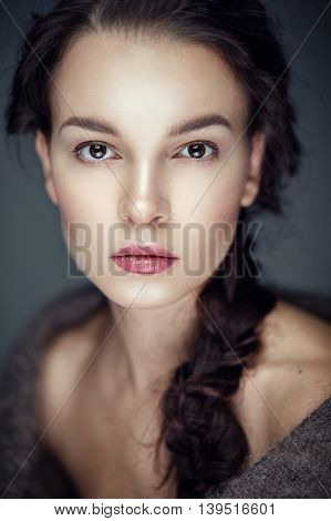 Fashion portrait of gorgeous young brunetee woman.Chaos hair style with braid. Shallow depth of field