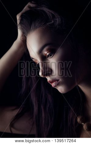 Fashion portrait of gorgeous young brunetee woman. Shallow depth of field. Low key portrait on black