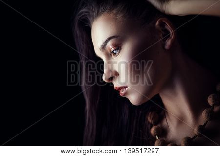 Fashion portrait of gorgeous young brunetee woman. Shallow depth of field. Low key portrait on black