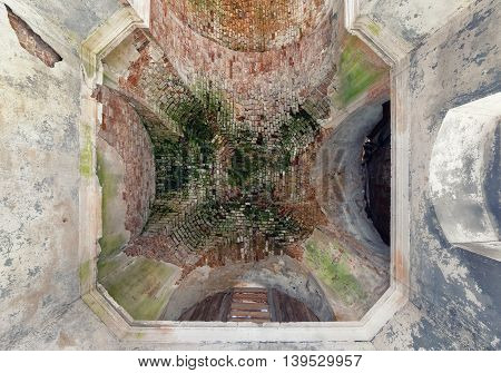 The old vault of the dome of an abandoned temple to sprinkle the plaster and moss-grown