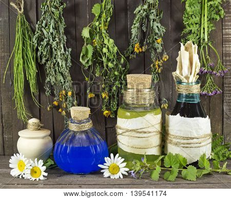 Still life with healing herbs and medical bottles on wooden shelf