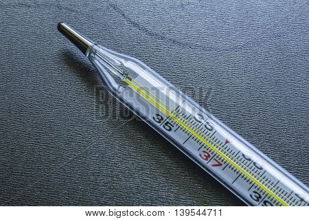 Medical Glass Mercury Thermometer On A Black Steel Background