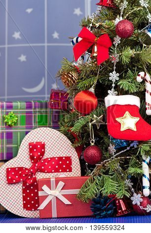Christmas toy balls with garland over presents and christmas spruce background