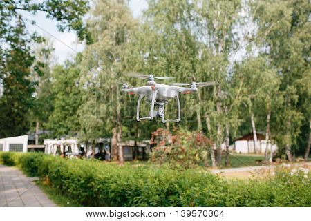 Videography wedding ceremony from the air a small spy quad copter scout drone flying through the trees in a forest.