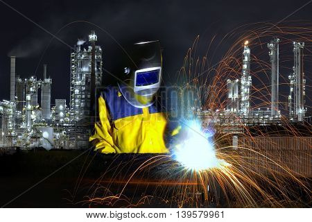 Welder welding and Twilight scene of chemical Oil refinery plants .