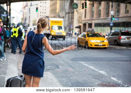 Girl calling/hailking taxi cab on Manhattan, New York City, USA
