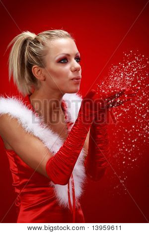Attracive sexet pige i santa klud snefygning fra hænder.