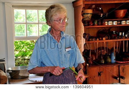 Mystic Connecticut- July 11 2015: Docent holding a stalk of Rhubarb giving a cooking demonstration in the 1768 Buckingham-Hall House kitchen at Mystic Seaport