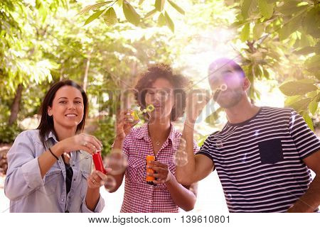 Three Funlovers Blowing Bubbles And Laughing