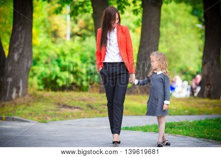 Mother brings her little daughter to school.