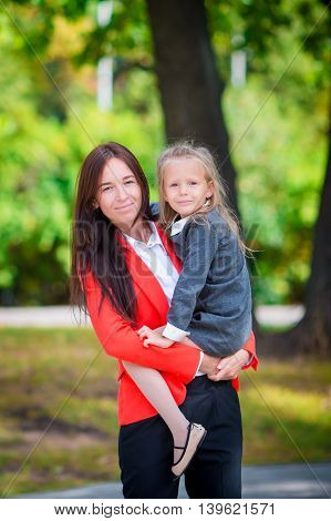 Mother brings her little daughter to school.