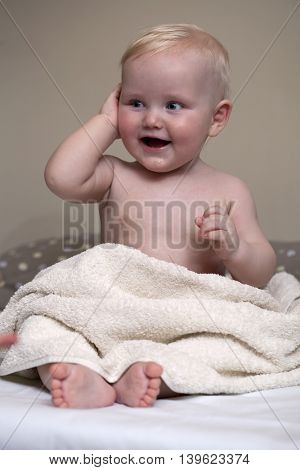 Baby boy with towel at home
