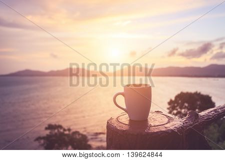 Coffee Cup At Sunset Or Sunrise Beach In The With Lens Flare. Warm Toning Effect. Retro And Vintage