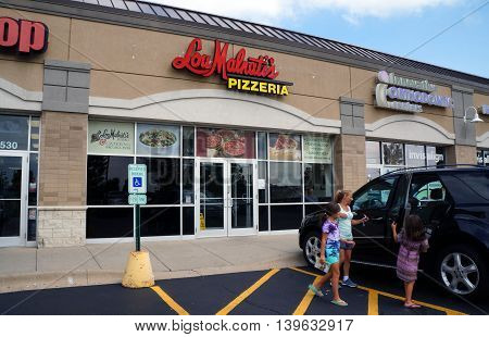 JOLIET, ILLINOIS / UNITED STATES - AUGUST 30, 2015: One may eat pizza at Lou Malnati's Pizzeria, in a Joliet strip mall.