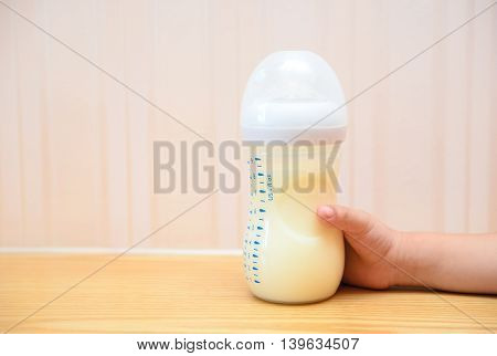 kid getting a baby bottle of powdered milk at home