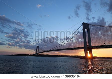 NEW YORK - JULY 23, 2016: Verrazano Bridge at sunset in New York .The Verrazano Bridge is a double-decked suspension bridge that connects the boroughs of Staten Island and Brooklyn