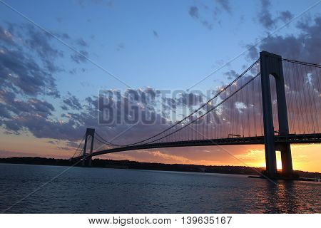 NEW YORK - JULY 23, 2016: Verrazano Bridge at sunset in New York .The Verrazano Bridge is a double-decked suspension bridge that connects the boroughs of Staten Island and Brooklyn