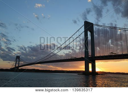 NEW YORK - JULY 23, 2016: Verrazano Bridge at sunset in New York .The Verrazano Bridge is a double-decked suspension bridge that connects the boroughs of Staten Island and Brooklyn