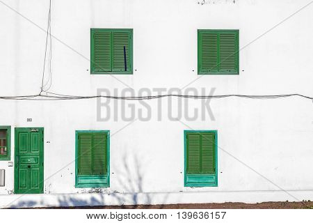 facade uf mediterranean house with closed shutterblinds at midday