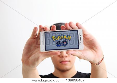 Kuala Lumpur,Malaysia 23th July 2016,teenager holding a smartphone with pokemon go logo on the screen
