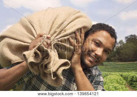 Brazilian coffee farmer at coffee plantation with coffee sack