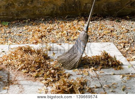 Pile of leaves with a broom being swept up