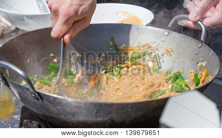 Street food. Noodles with vegetables fried in a frying pan.