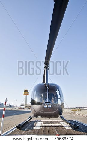 Helicopter at the airport, in front of blue sky.