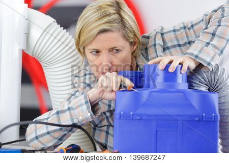 female electrician reapiring machinery