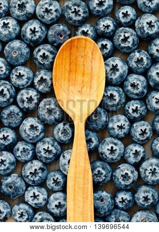 Wooden spoon on a background of blueberries. Top view.