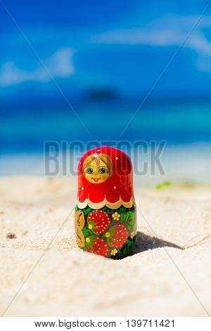 Photo Russian Dolls Matrioshka Souvenir Untouched Sunny Tropical Beach in Bali Island. Vertical Picture. Blurred Background. Closeup