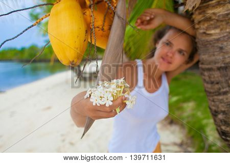 Photo young girl relaxing on beach with flowers. Smiling woman spending chill time outdoor summer Bali island. Horizontal picture Closeup