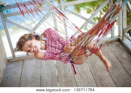 Photo young sexy girl relaxing on beach Bungalow in hammock. Smiling woman spending chill time outdoor summer. Caribbean Ocean Vacations. Horizontal, blurred background