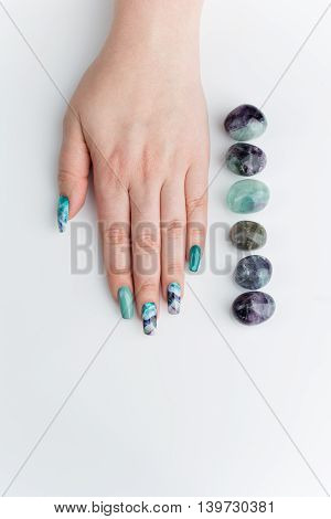 Closeup of woman nails with creative purple and green manicure. Fluorinit print. Copy space.