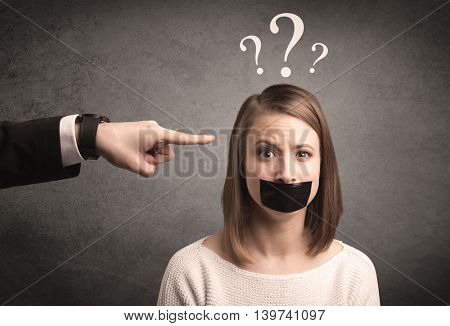 Caucasian business hand pointing at female employee with big white question mark above her head