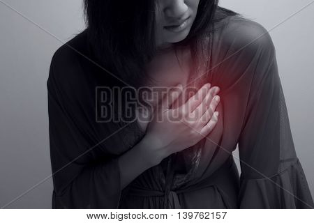 Woman is clutching her chest, acute pain possible heart attack