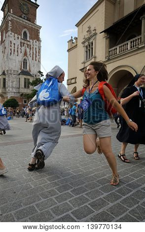 CRACOW POLAND - JULY 24 2016: Pilgrims of World Youth Day sing and dance on the Main Square in Cracow. Poland