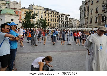 CRACOW POLAND - JULY 24 2016: Pilgrims of World Youth Day sing and dance on the Main Square in Cracow. Poland