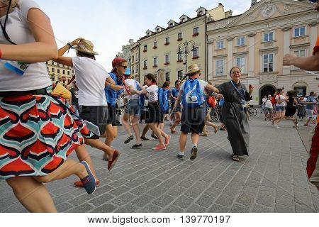 CRACOW POLAND - JULY 24 2016: Pilgrims of World Youth Day sing and dance on the Main Square in Cracow. Poland