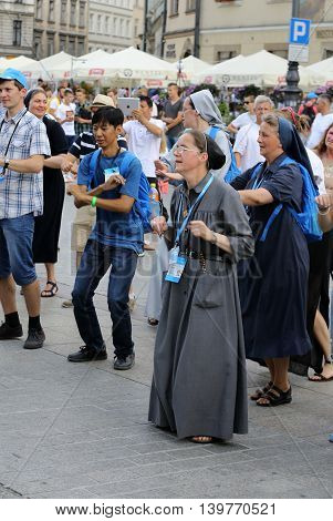CRACOW POLAND - JULY 24 2016: Pilgrims of World Youth Day sing and dance on the Main Square in Cracow. Poland