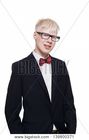Albino young man portrait. Blond guy in suit with red bow tie isolated at white background. Albinism, pale skin. Stylish young boy in eye glasses and suit.