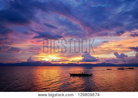 Amazing colorfull sunset at the sea with philippine boat in Moalboal