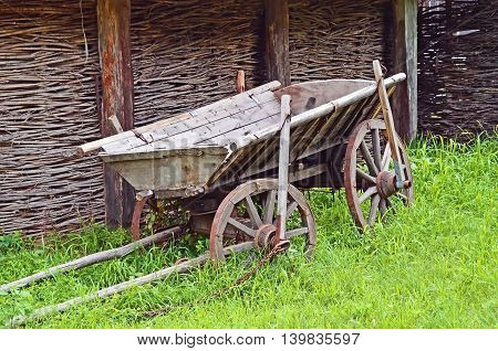 Ancient wooden cart standing on a green grass