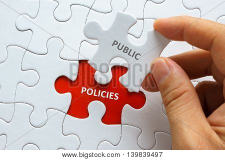 Hand Holding Piece Of Jigsaw Puzzle With Word Public Policies.