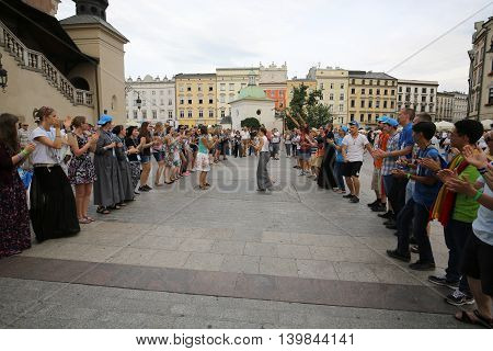 CRACOW POLAND - JULY 24 2016: Pilgrims of World Youth Day sing and dance on the Main Square in Cracow. Poland