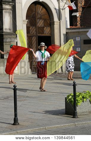 CRACOW POLAND - JULY 24 2016: Pilgrims of World Youth Day sing and dance on the St. Maria Magdalena Square in Cracow. Poland